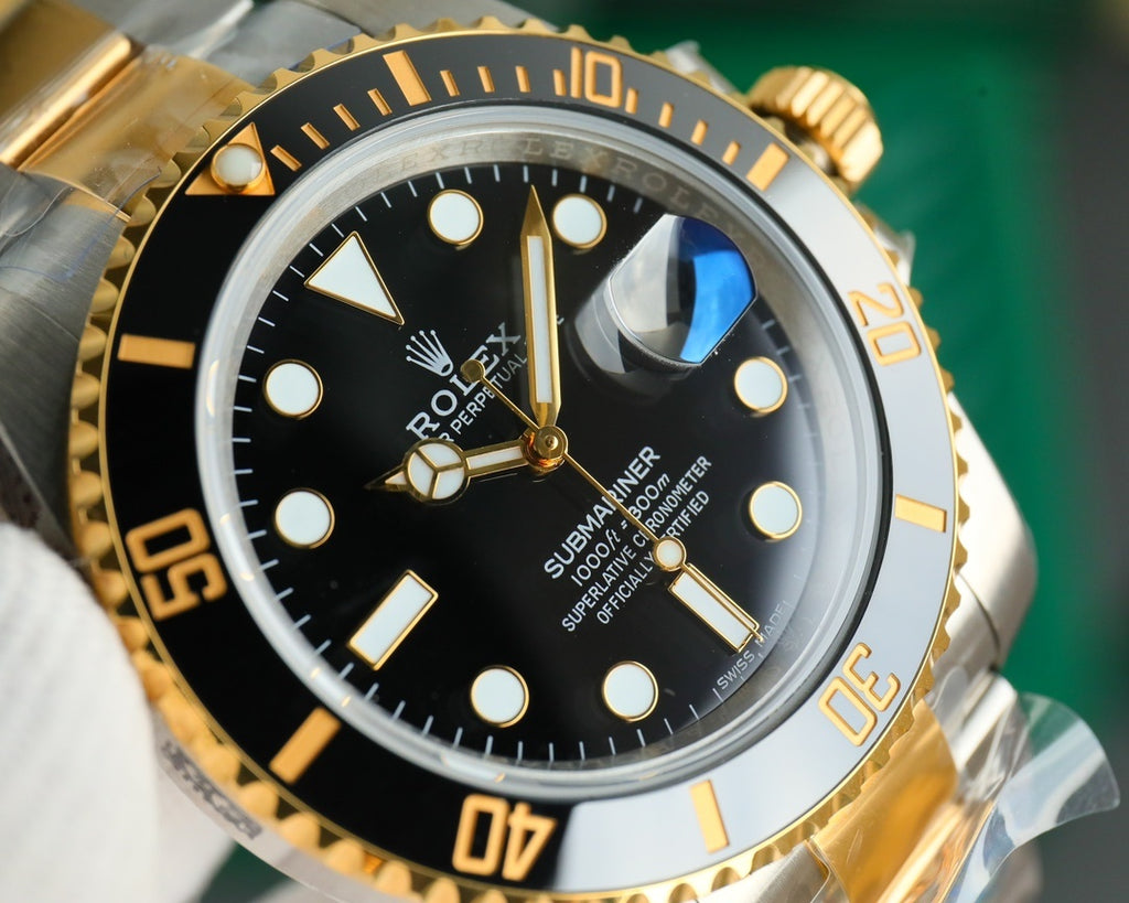 Rolex watch close-up of black dial with gold hands, markers, and day-date detail