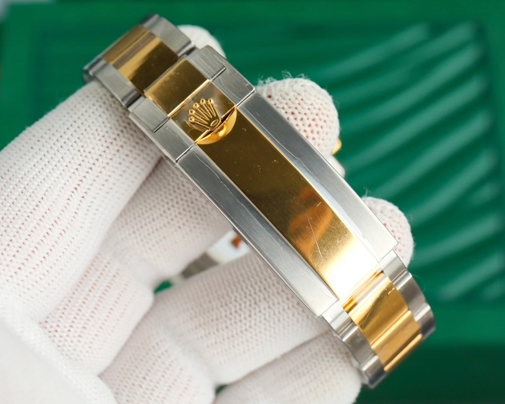 Rolex watch side view with gold center bracelet links and polished metal case