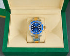 Rolex watch in display box, blue dial and gold bezel with steel-and-gold bracelet