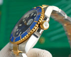 Rolex watch close-up of blue bezel, gold accents, and crown on steel case