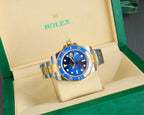 Rolex watch with blue dial, gold bezel, and steel-and-gold bracelet in box