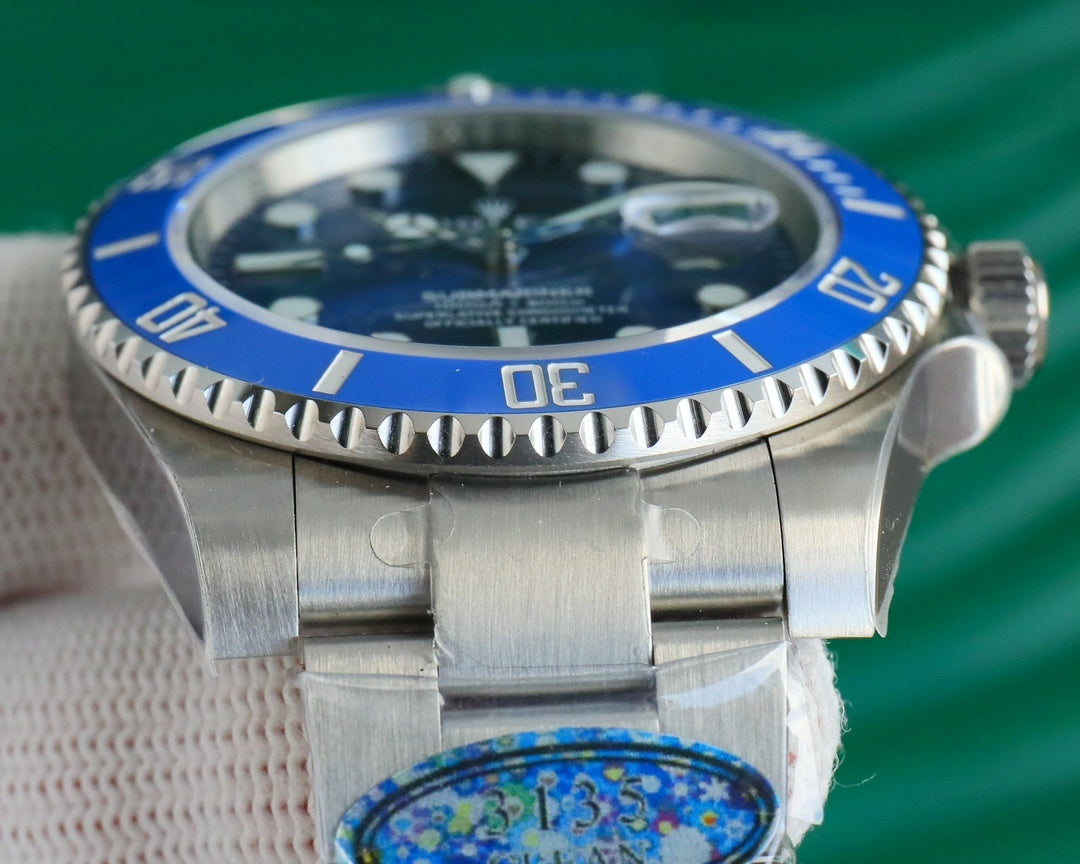 Stainless steel wristwatch with blue bezel and bracelet, close-up dial view