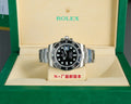 Rolex watch with black dial, black bezel, and stainless steel bracelet on display box