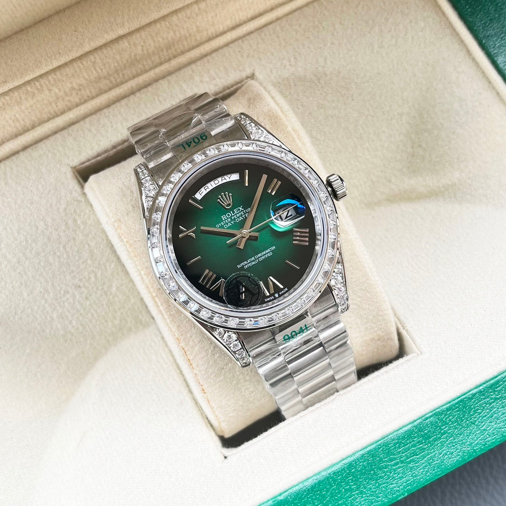 Rolex watch in display box with green dial and diamond-set bezel