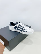 Pair of white low-top sneakers with navy patterned details on a box