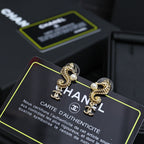Gold-tone drop earrings with pearl centers and Chanel CC logo charm, close view