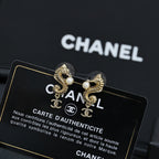 Gold-tone earrings with pearl accents and Chanel CC charm, close-up pair