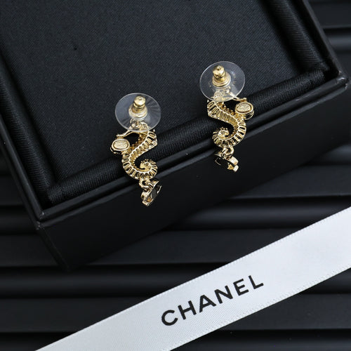 Gold-tone drop earrings with pearl accents and Chanel CC charm detail, angled pair