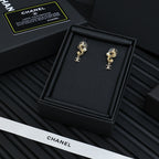 Gold-tone dangle earrings with pearls and Chanel CC logo charm, front view