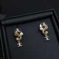 Gold-tone dangle earrings with pearl accents and Chanel CC charm drop, pair