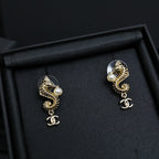 Gold-tone dangle earrings with pearl accents and Chanel CC charm drop, pair