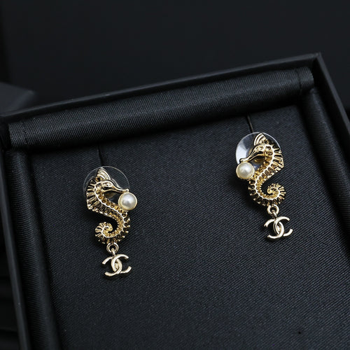 Gold-tone dangle earrings with pearl accents and Chanel CC charm drop, pair