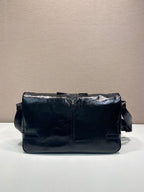 Dark navy leather shoulder bag with front flap and snap details