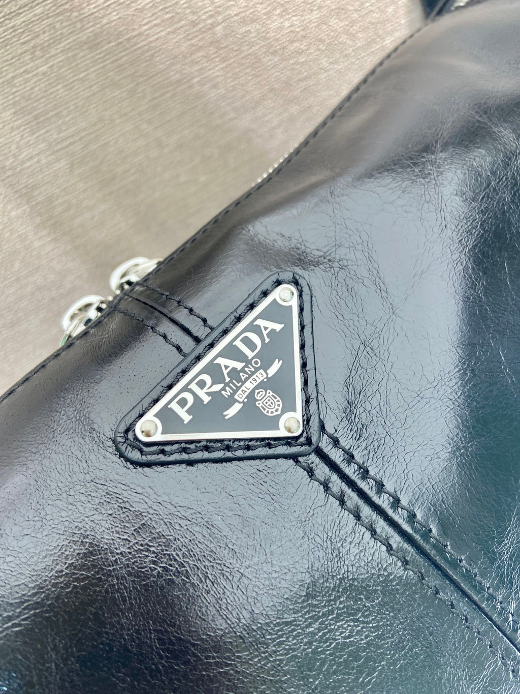 Dark navy leather bag with Prada triangular logo plaque and stitched trim