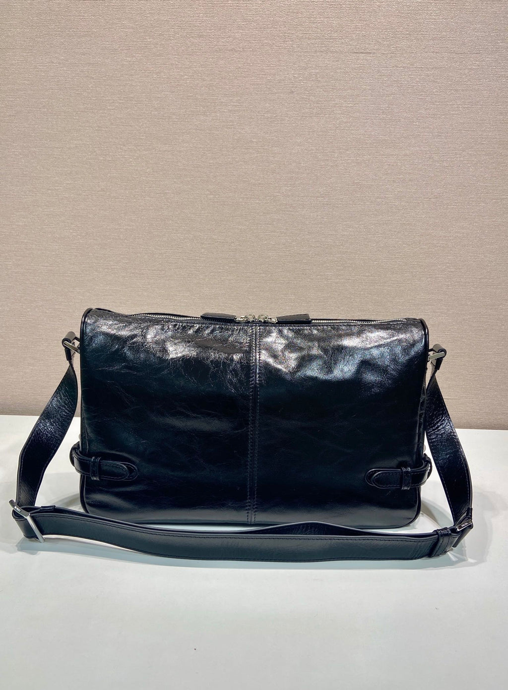 Dark navy leather crossbody bag with adjustable strap and front flap