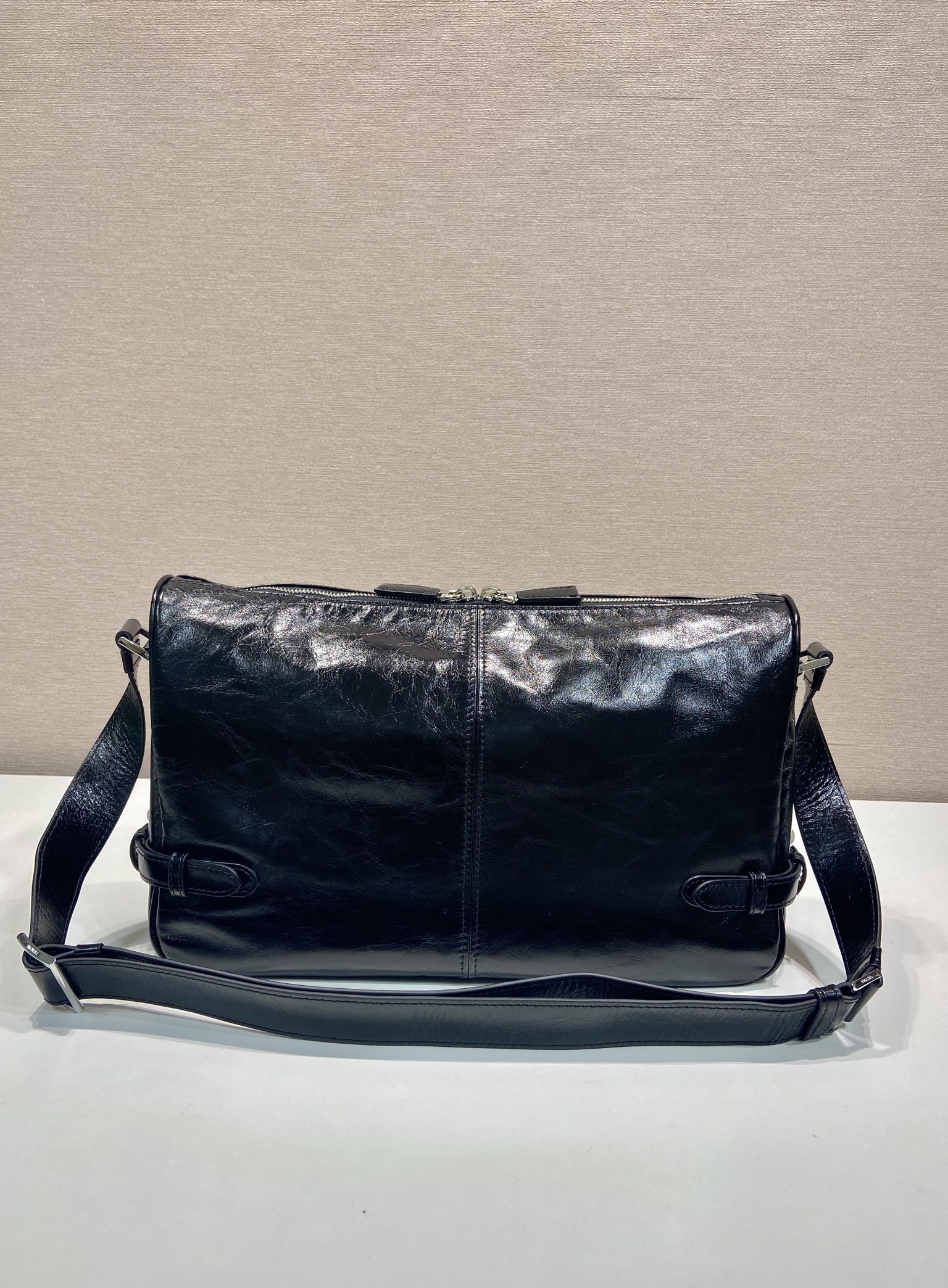 Dark navy leather crossbody bag with adjustable strap and front flap