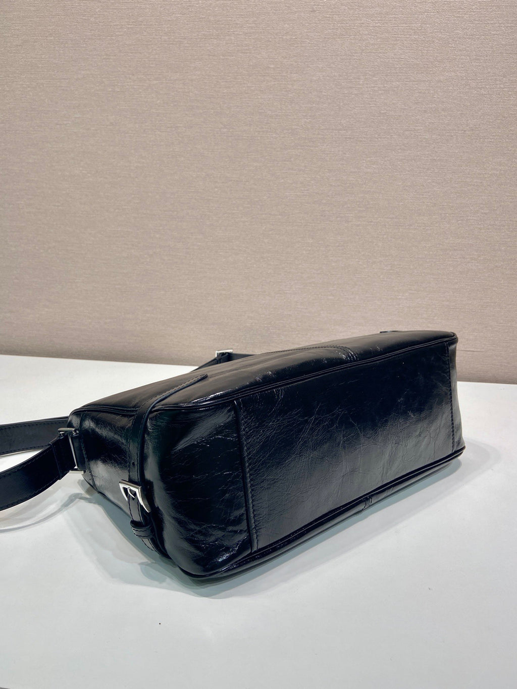 Dark navy leather handbag with short strap and curved top edge