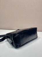 Dark navy leather handbag with short strap and curved top edge