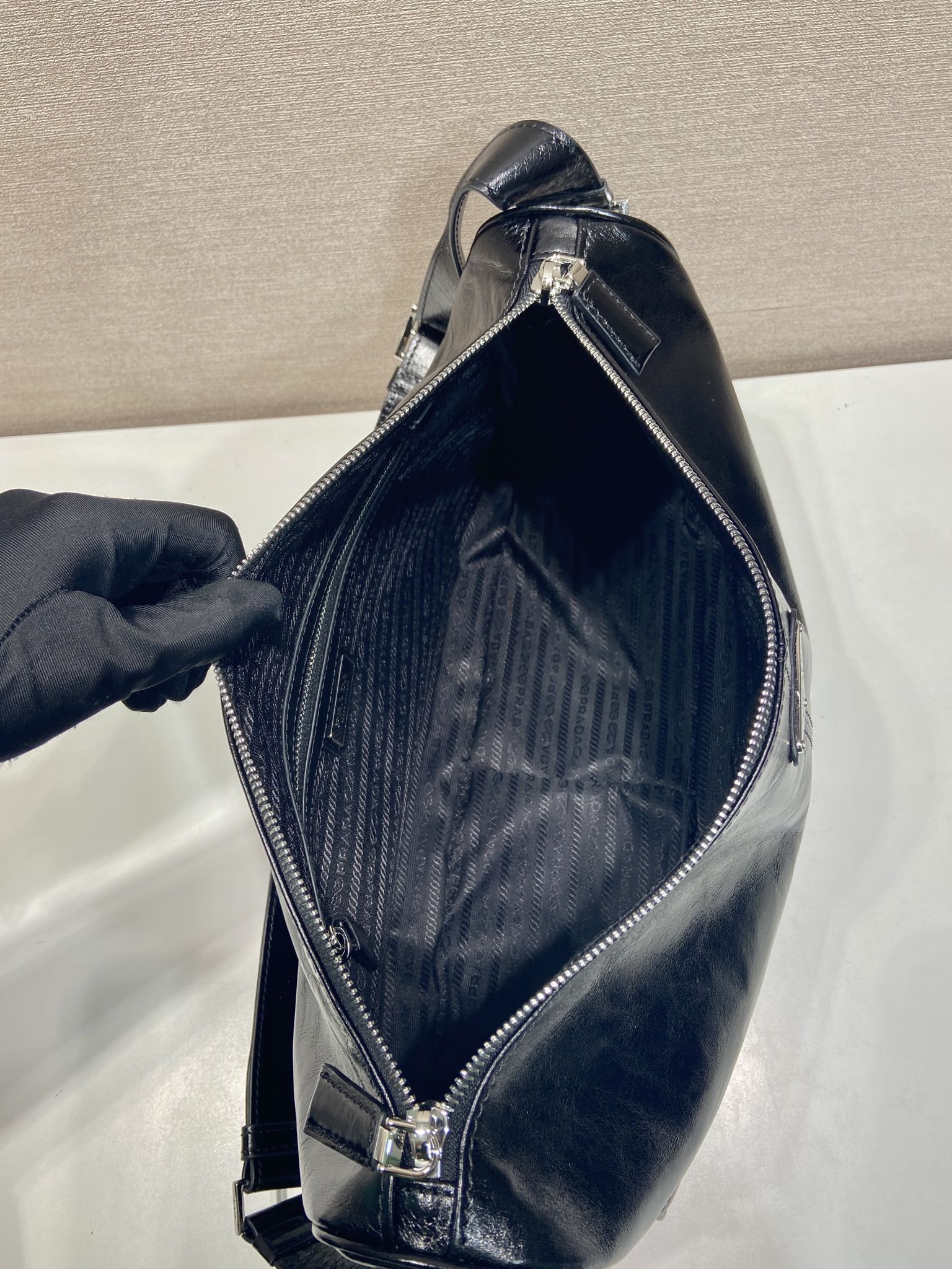 Dark navy leather crossbody bag with open zipper and visible interior lining