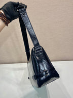 Dark navy leather crossbody bag with wide strap and metal buckle hardware