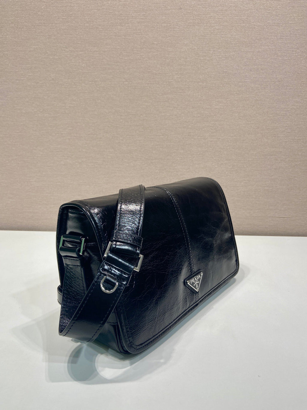 Dark leather flap shoulder bag with buckle strap detail and triangle logo