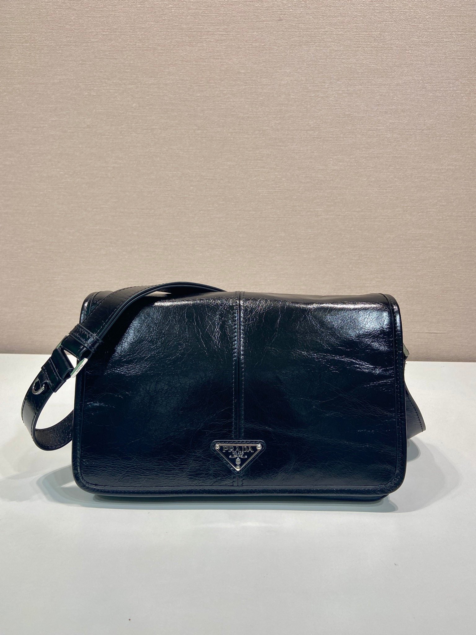 Prada shoulder bag in dark leather with front triangle logo and flap