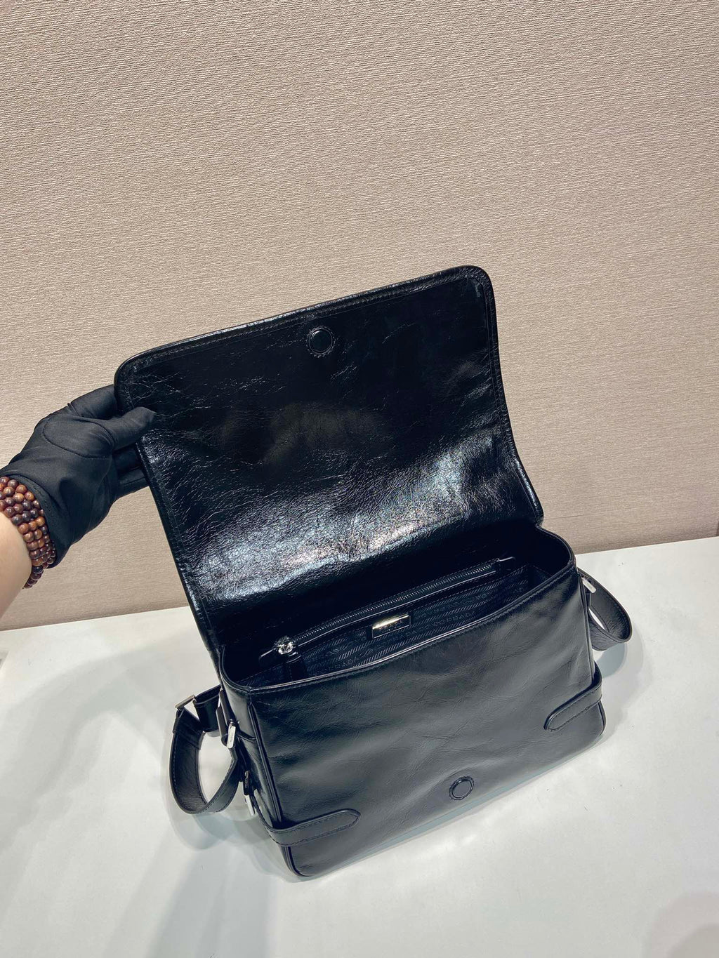 Dark leather small crossbody bag with flap top and visible front zipper detail