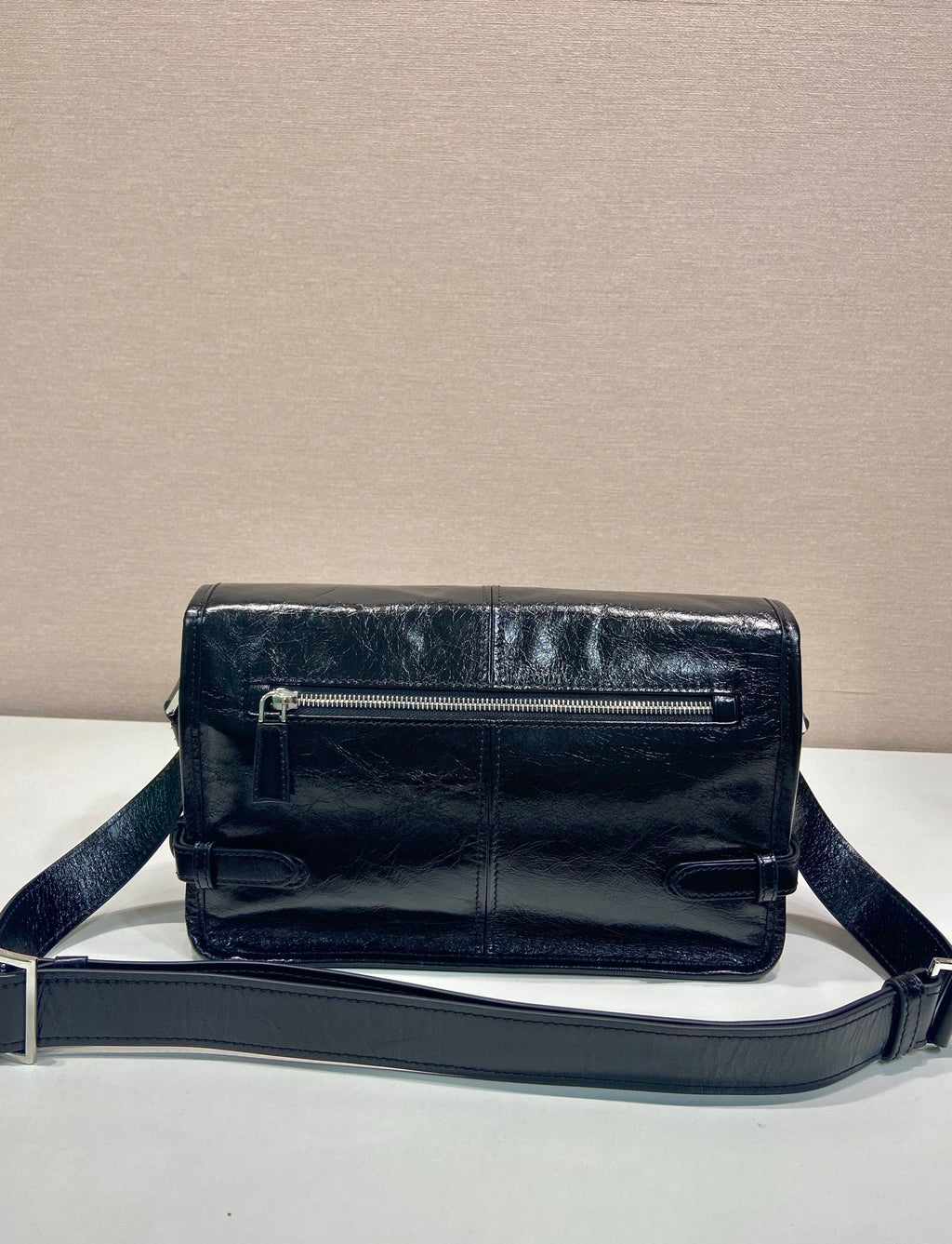 Dark leather crossbody bag with top zip and adjustable shoulder strap