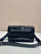 Dark leather crossbody bag with top zip and adjustable shoulder strap