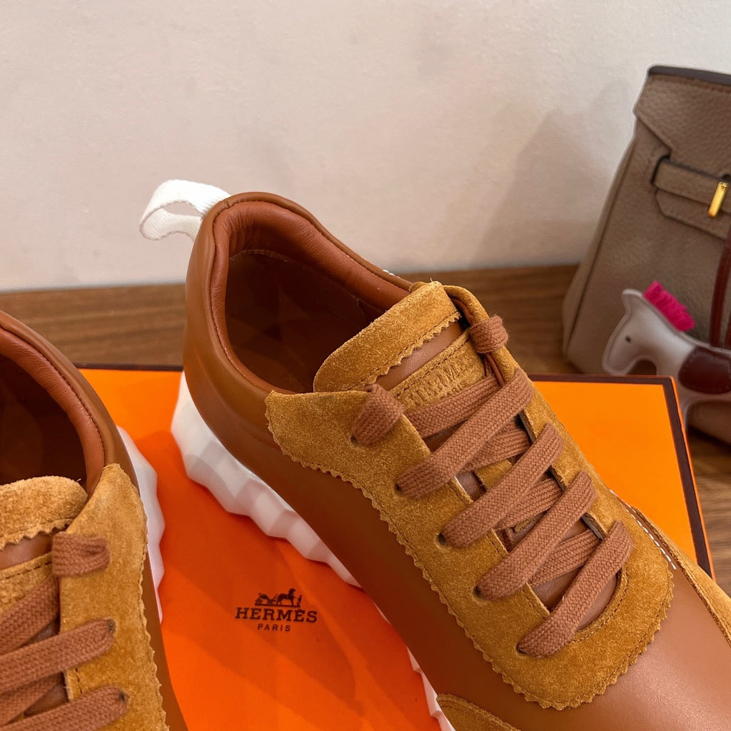 Hermes unisex sneaker upper close-up in tan suede with lace-up eyelets and heel tab