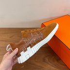 Hermes unisex sneaker close-up in tan suede with white ribbed sole and lace-up