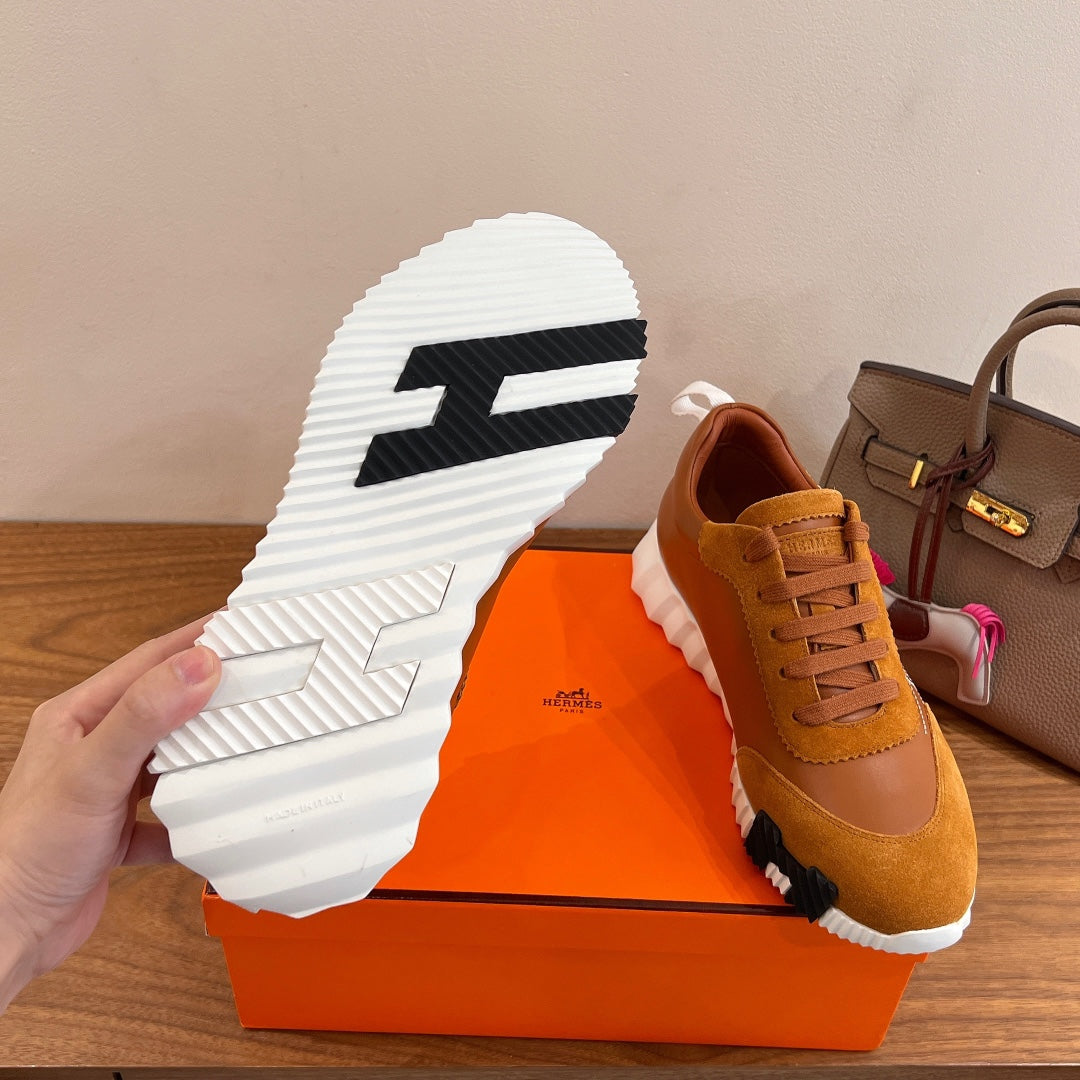 Hermes unisex sneaker outsole, white tread with black logo stripe and tan upper