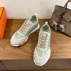 Pair of low-top unisex sneakers in light green and white, lace-up, textured rubber sole
