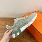 Single low-top sneaker in light green and white with lace-up closure and ridged sole