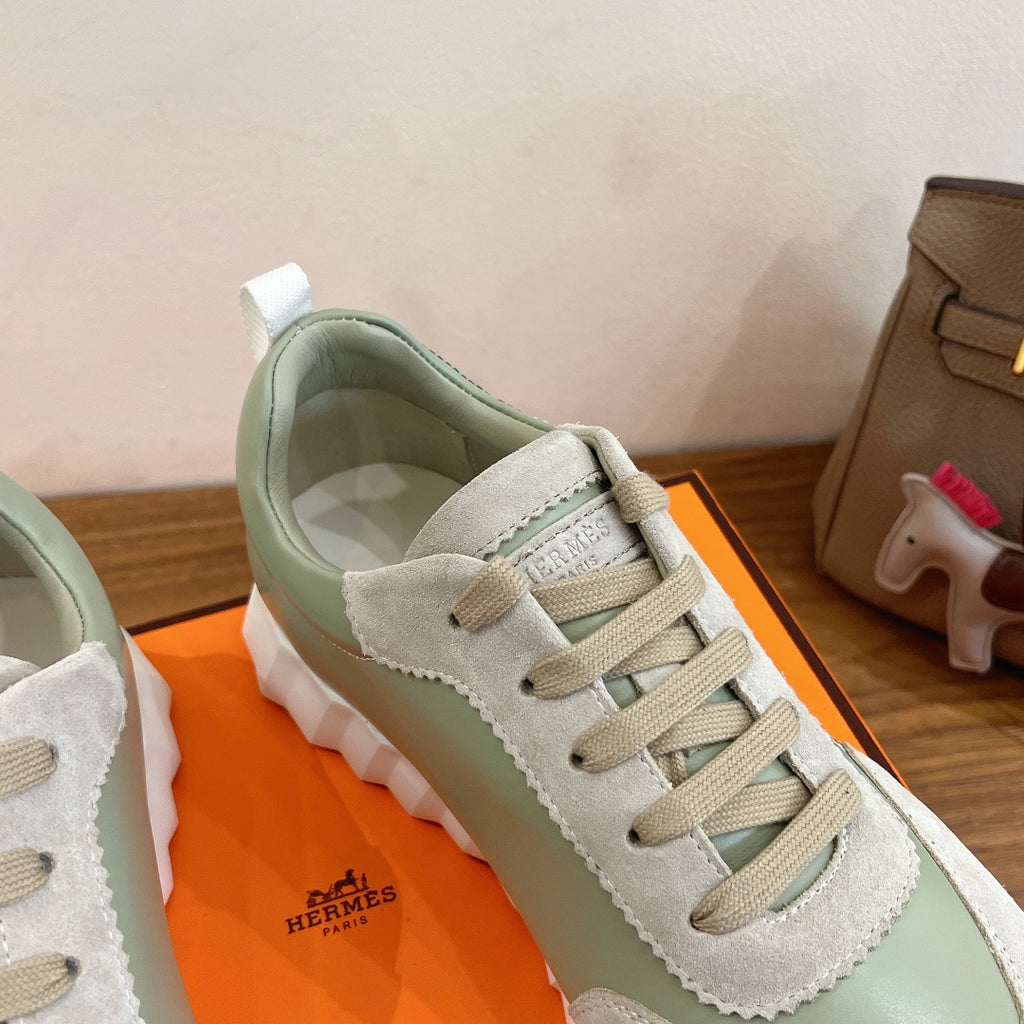 Low-top sneaker detail: lace-up front, suede and leather-like panels in light green and white