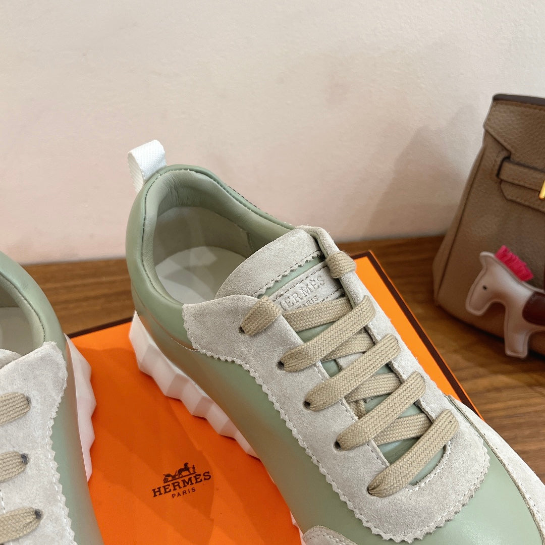 Low-top sneaker detail: lace-up front, suede and leather-like panels in light green and white