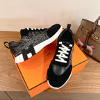Black Hermes unisex sneakers with white laces, geometric side stitching, cushioned sole