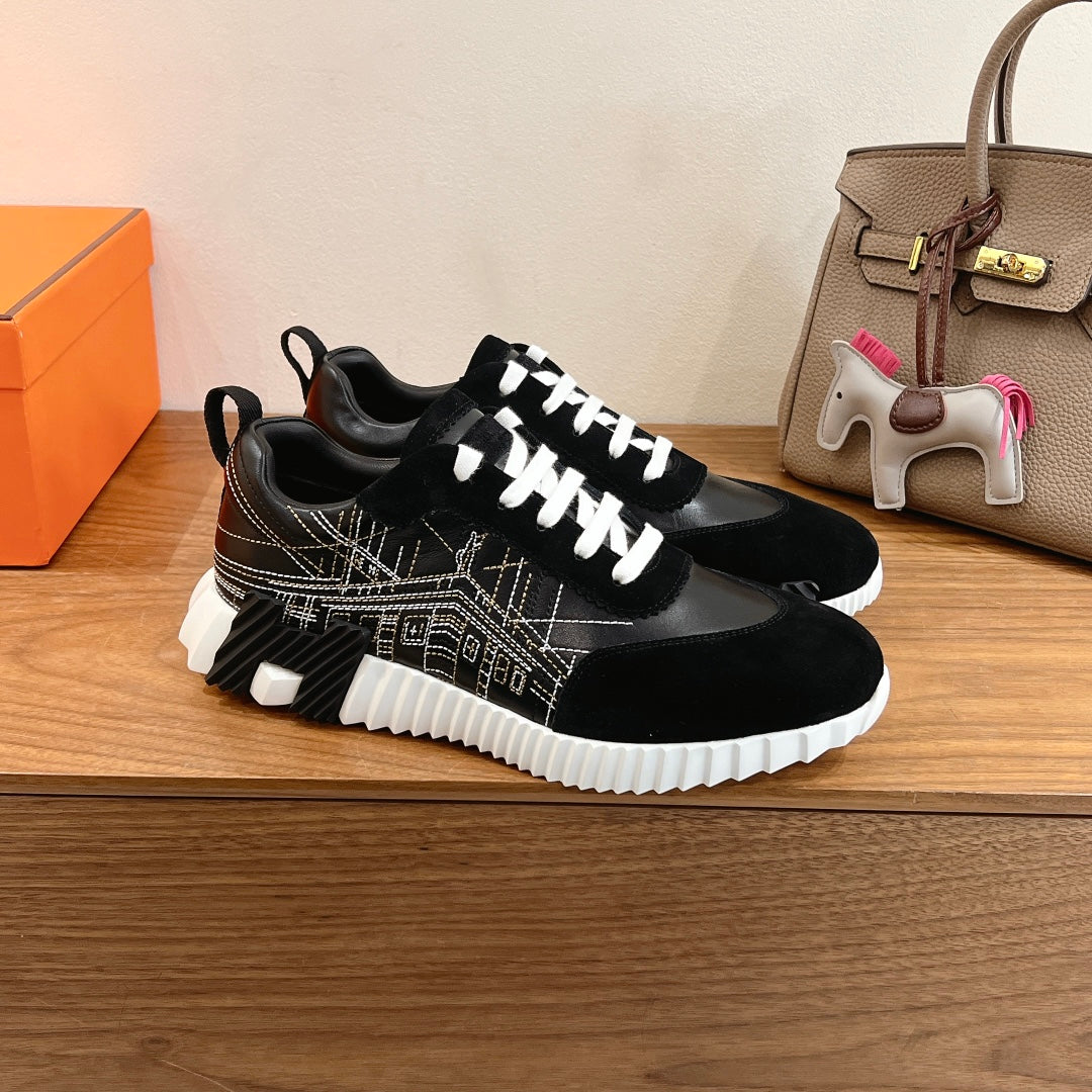 Black Hermes unisex sneakers with white lace-up closure, patterned side panels, white tread