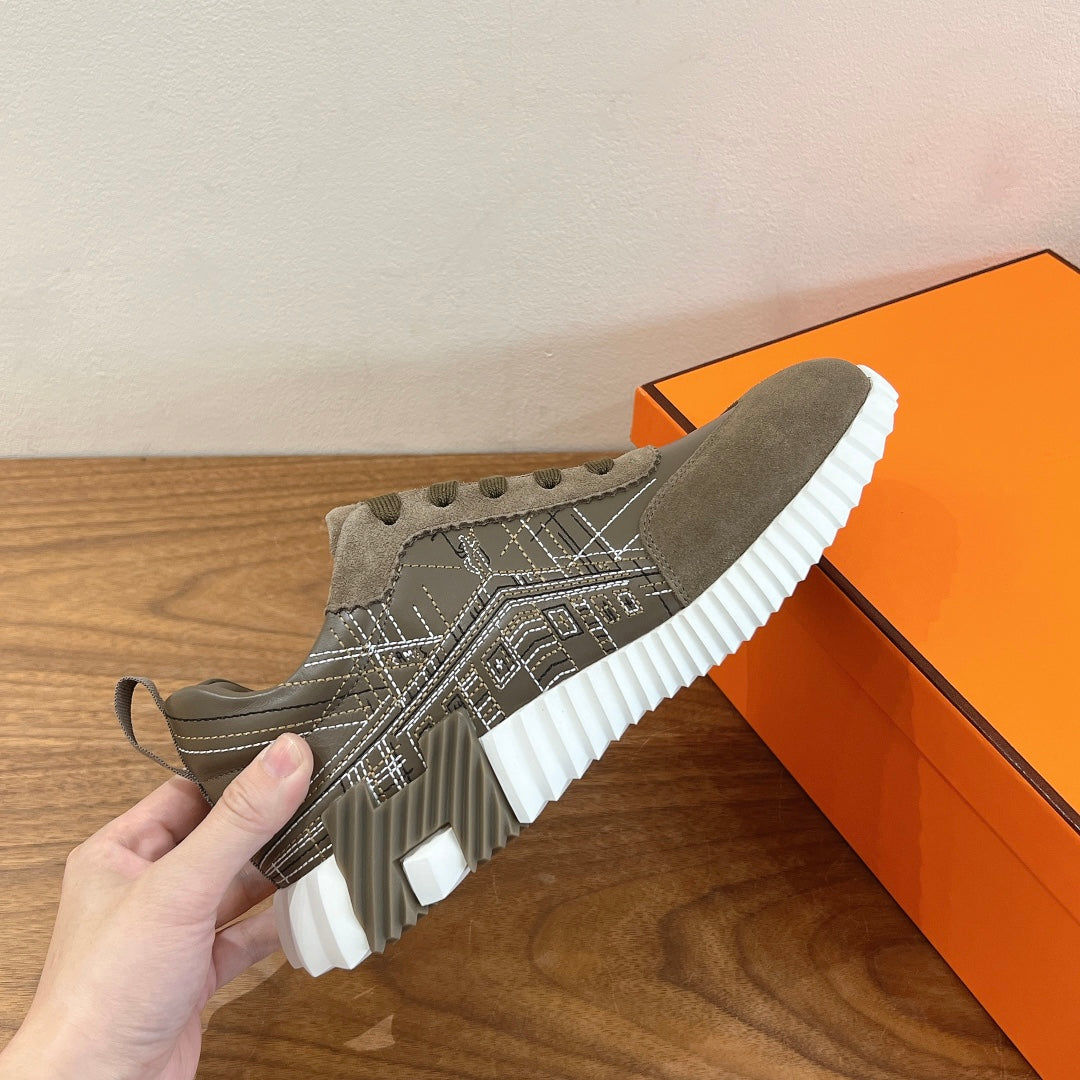 Hermes unisex sneaker close-up with olive suede upper and white ridged sole