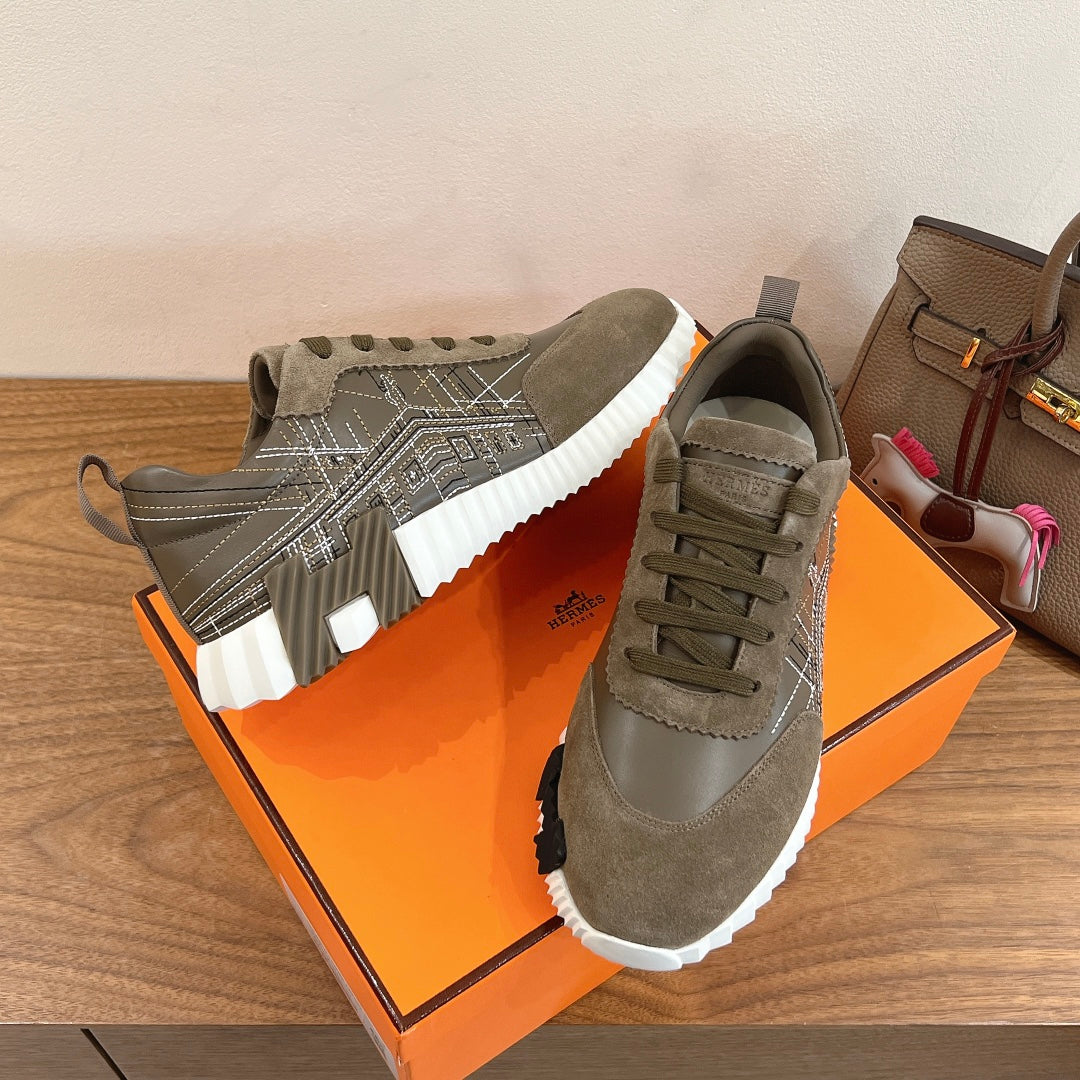 Hermes unisex sneakers showing side with olive suede panels and white rubber sole