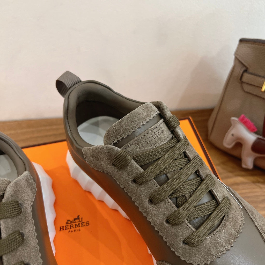 Hermes unisex sneaker close-up at toe and laces in olive suede with white sole