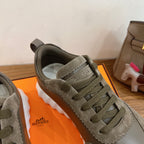 Hermes unisex sneaker close-up at toe and laces in olive suede with white sole