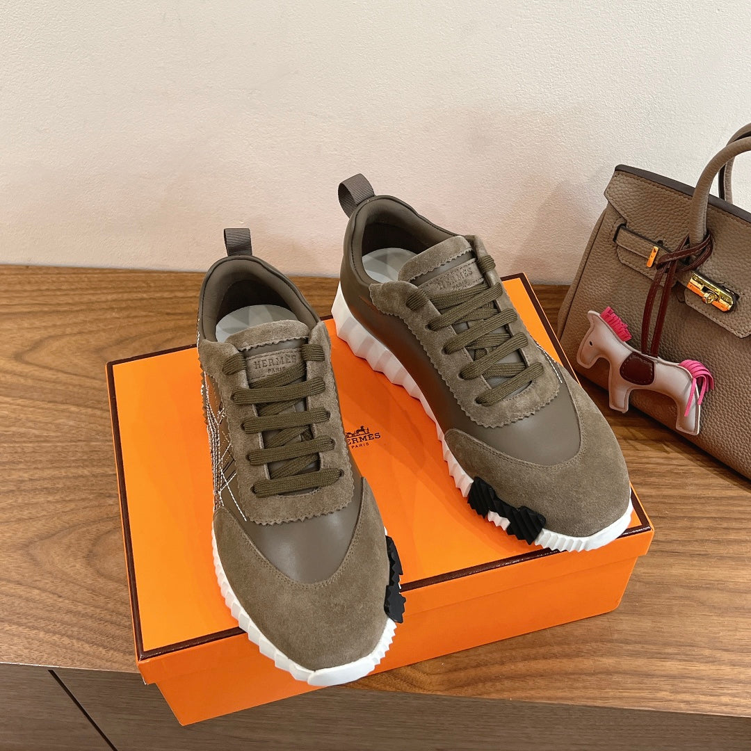 Hermes unisex sneakers in olive suede on orange box, pair view with lace-up design