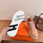 Hermes unisex sneaker showing tread sole, light pink upper with white rubber outsole