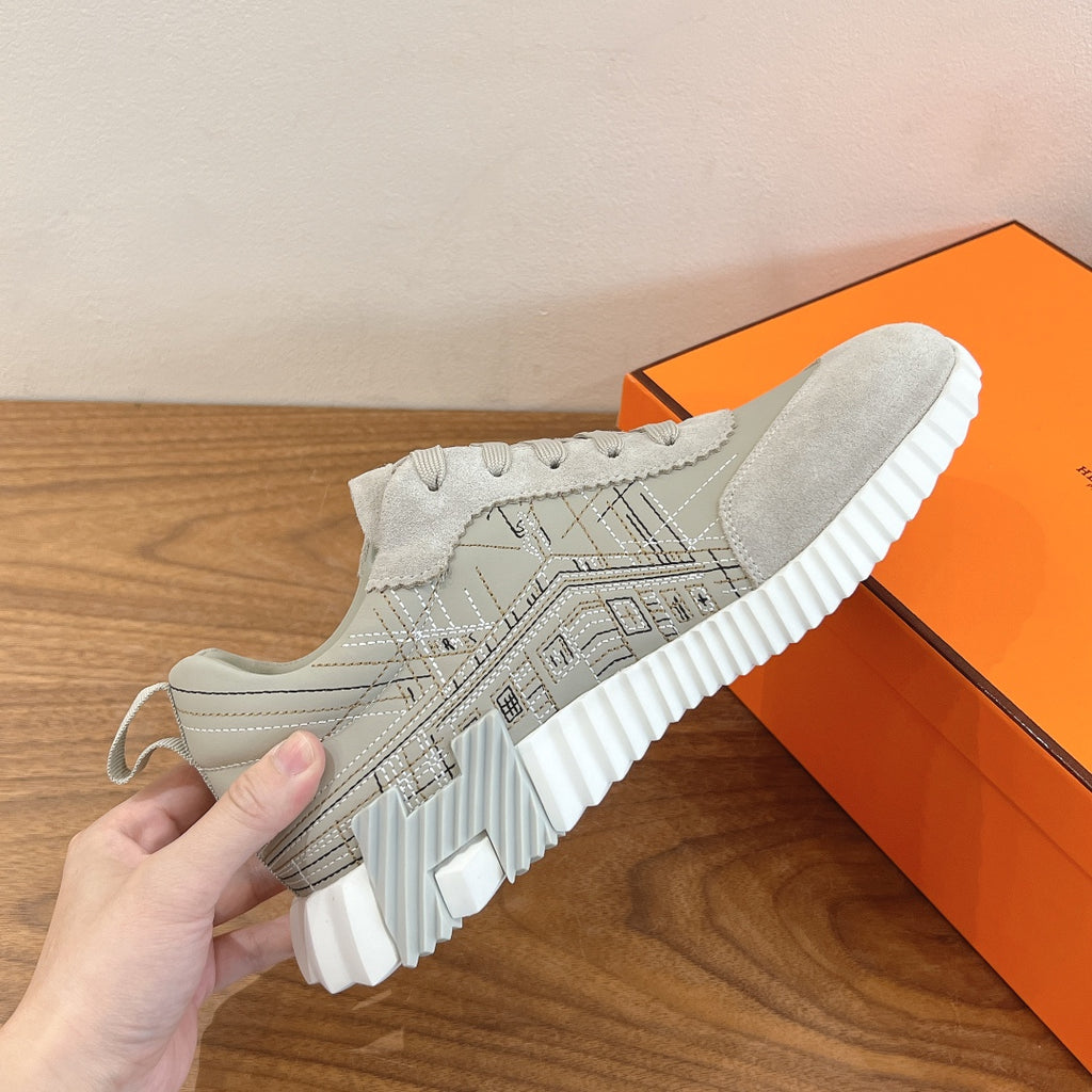 White lace-up sneakers with geometric pattern on upper and ribbed midsole, close-up.