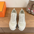White lace-up sneakers with padded collar and cushioned white rubber sole, unisex.