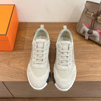 White lace-up sneakers with padded collar and cushioned white rubber sole, unisex.