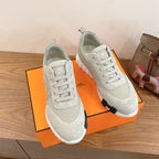 White lace-up sneakers with contrast sole edge detail and cushioned collar, unisex.