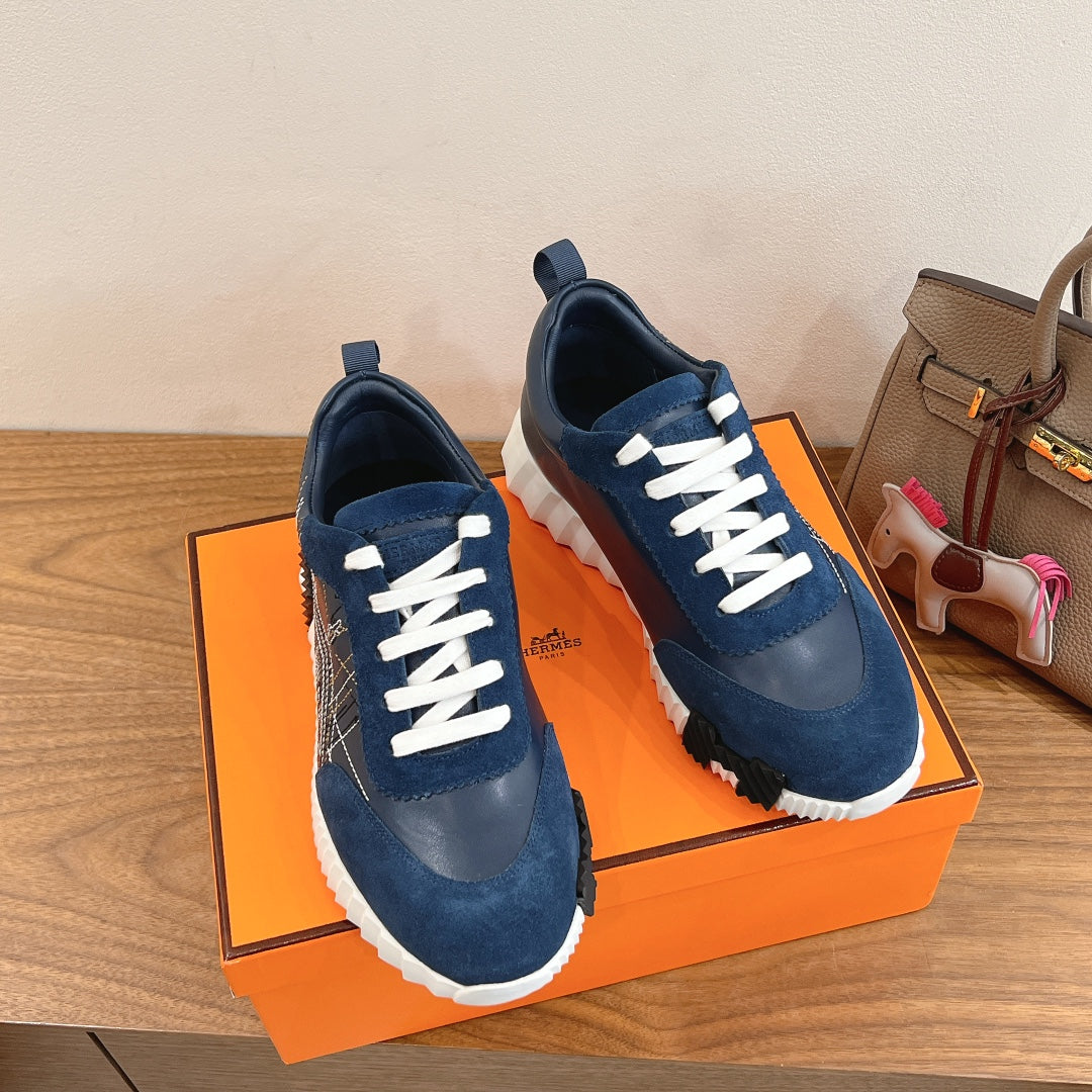 Unisex blue sneakers with white laces, front and side views on orange box