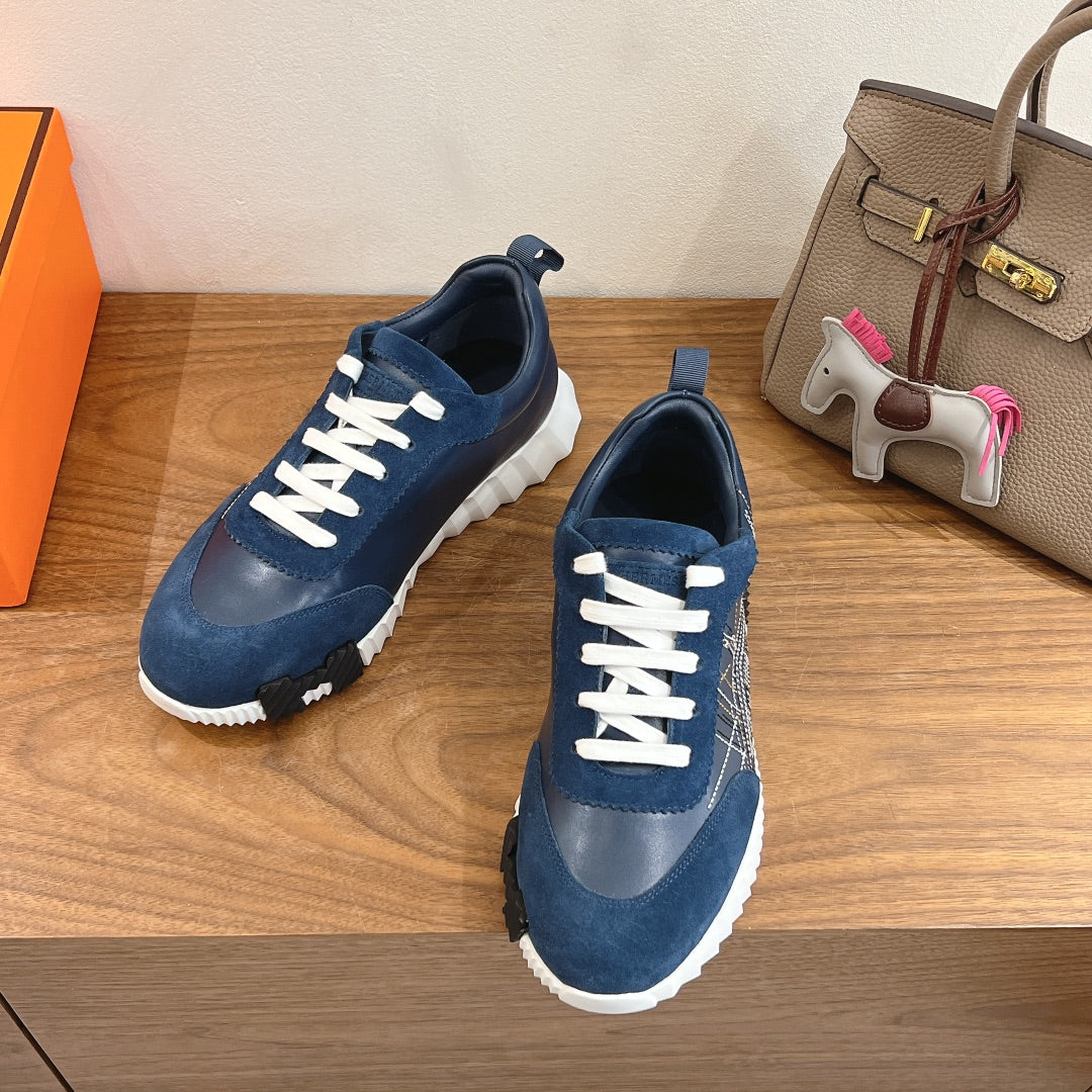 Pair of unisex blue sneakers with white laces and thick white soles